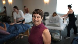 Instructor Chula Linda Gemignani standing in front of a prenatal massage class
